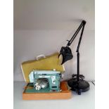 A 20th century New Home electric sewing machine in case together with an angle poise magnifying