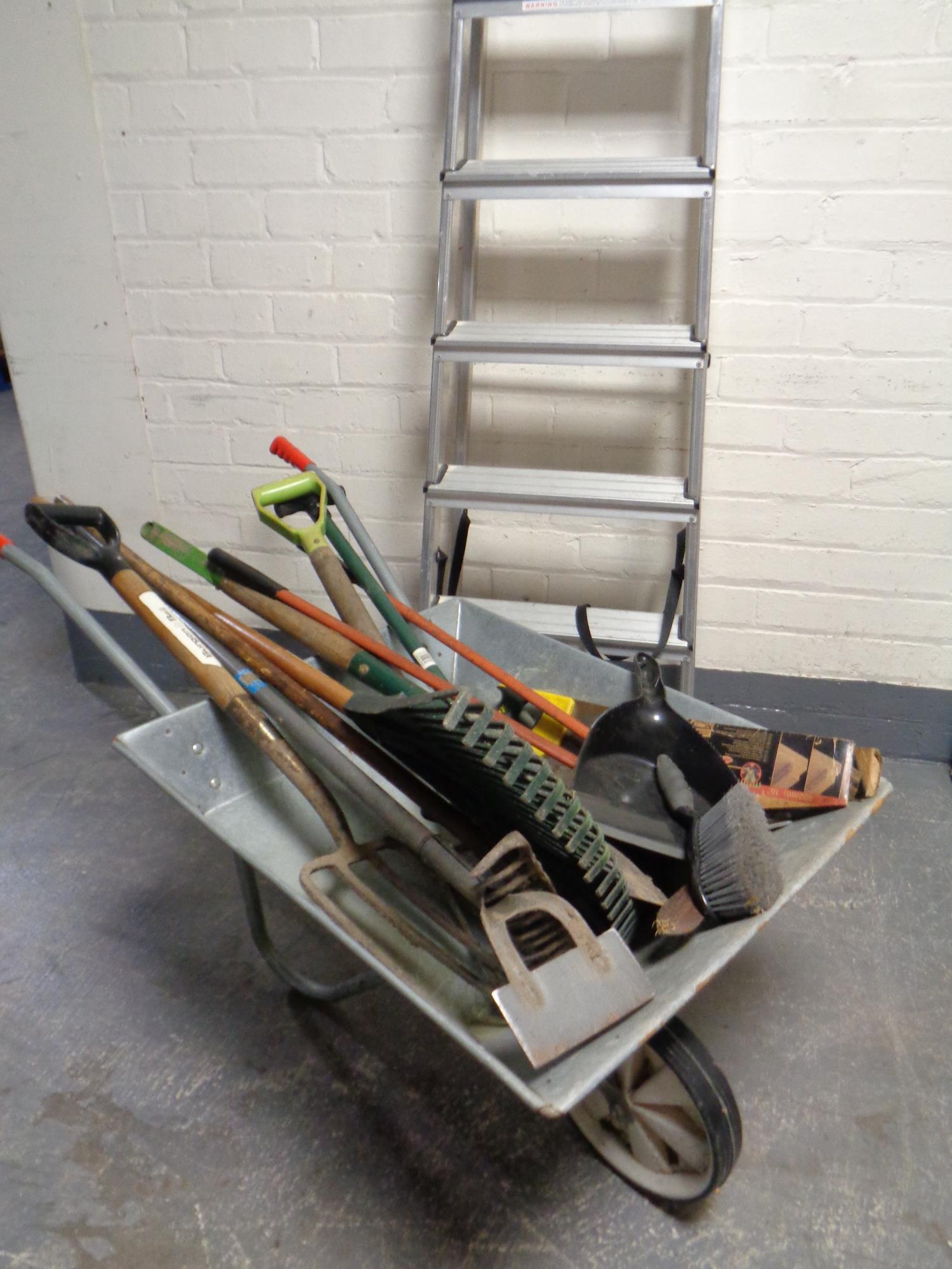 A metal wheelbarrow containing an assortment of garden tools together with a set of aluminium