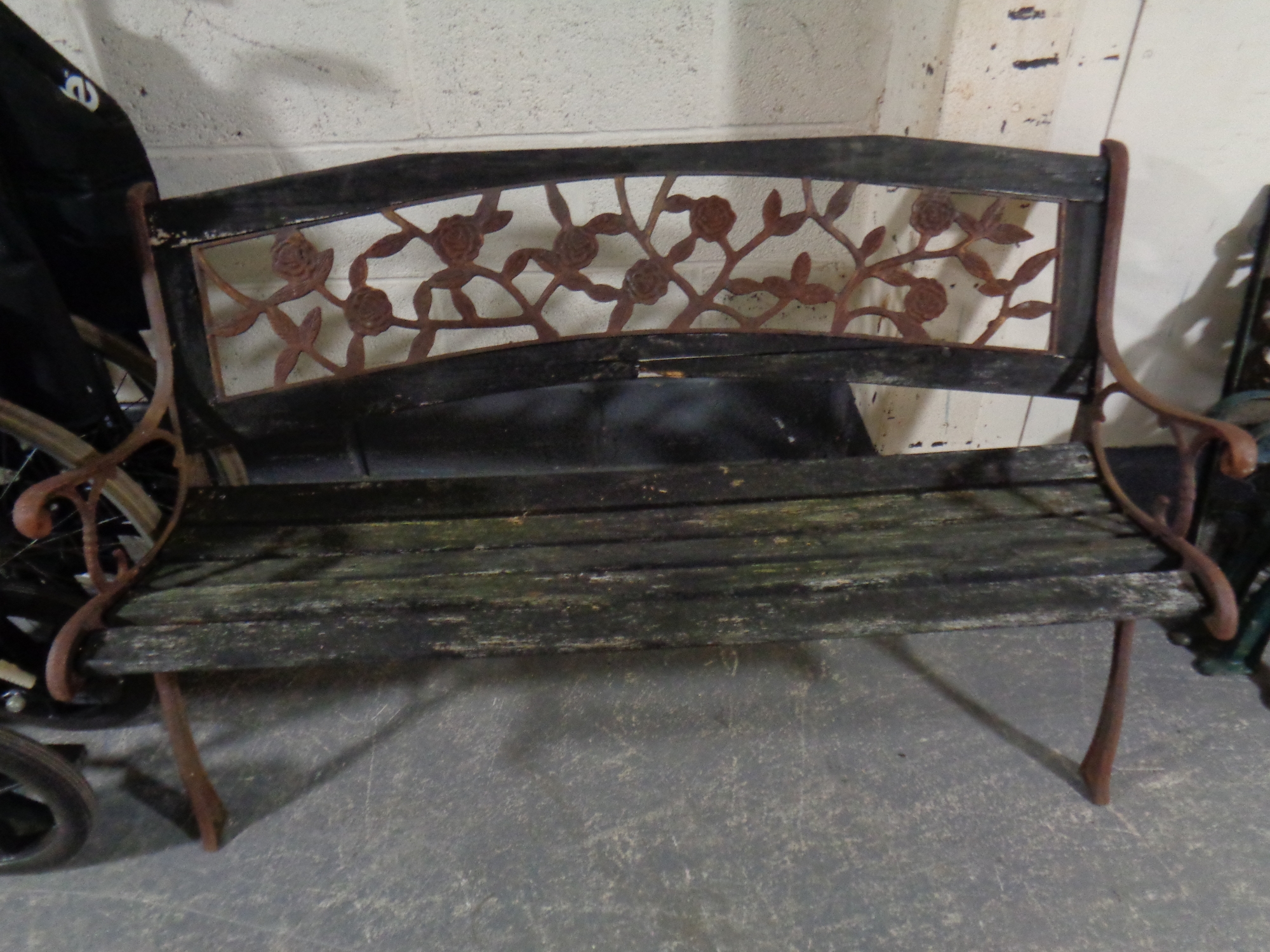 A wooden slatted cast iron ended garden bench together with two further sets of cast iron bench