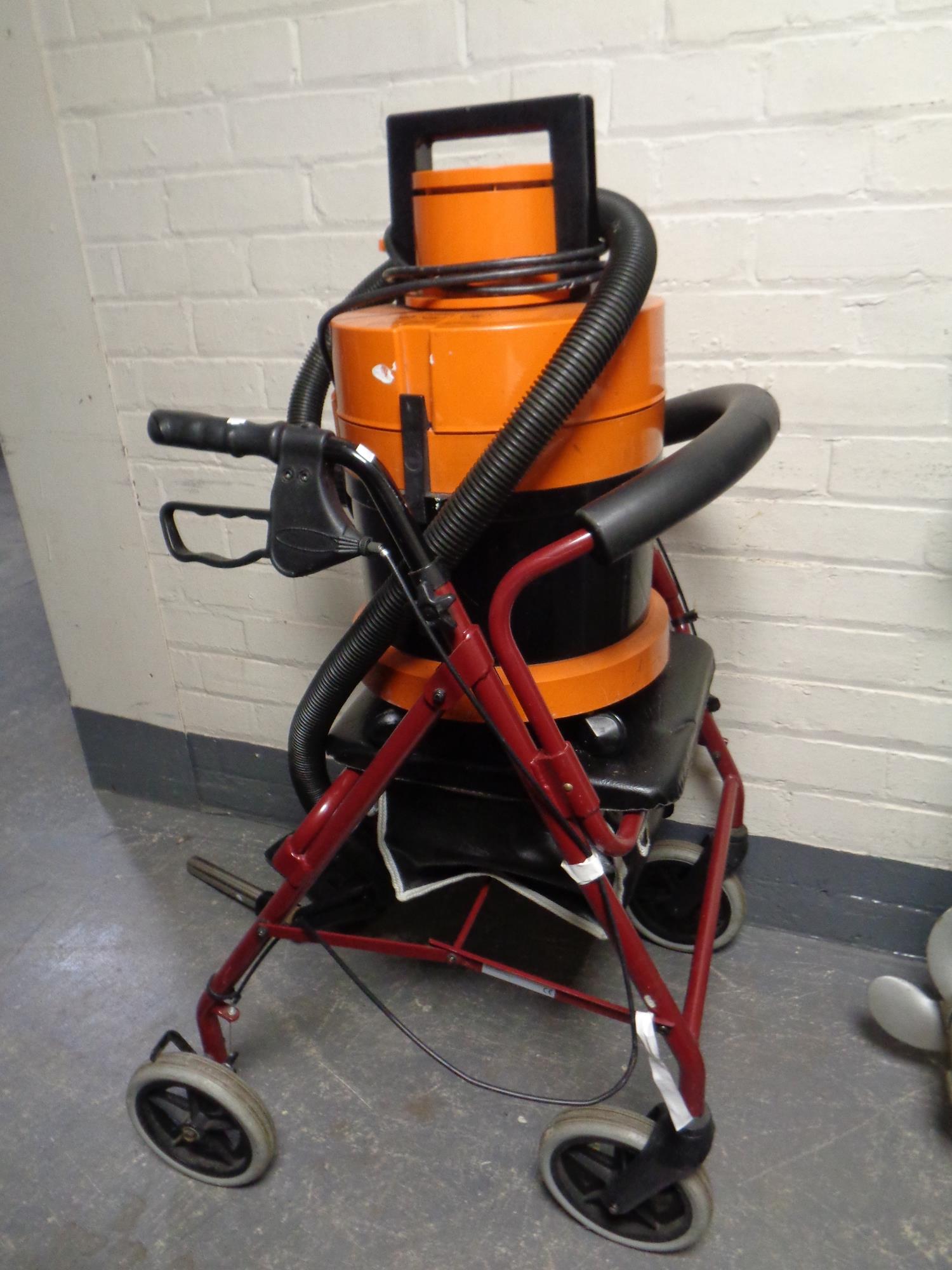 A disability walking aid together with a cylinder Vax and a Vax steam cleaner