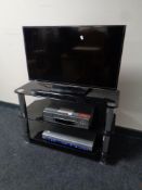 A Samsung UE32H5500AK LCD TV with remote on three tier stand,