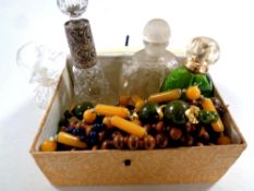 A box of beaded costume necklaces together with four perfume bottles,