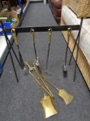 A four piece cast iron and brass companion set on stand together with four further antique brass