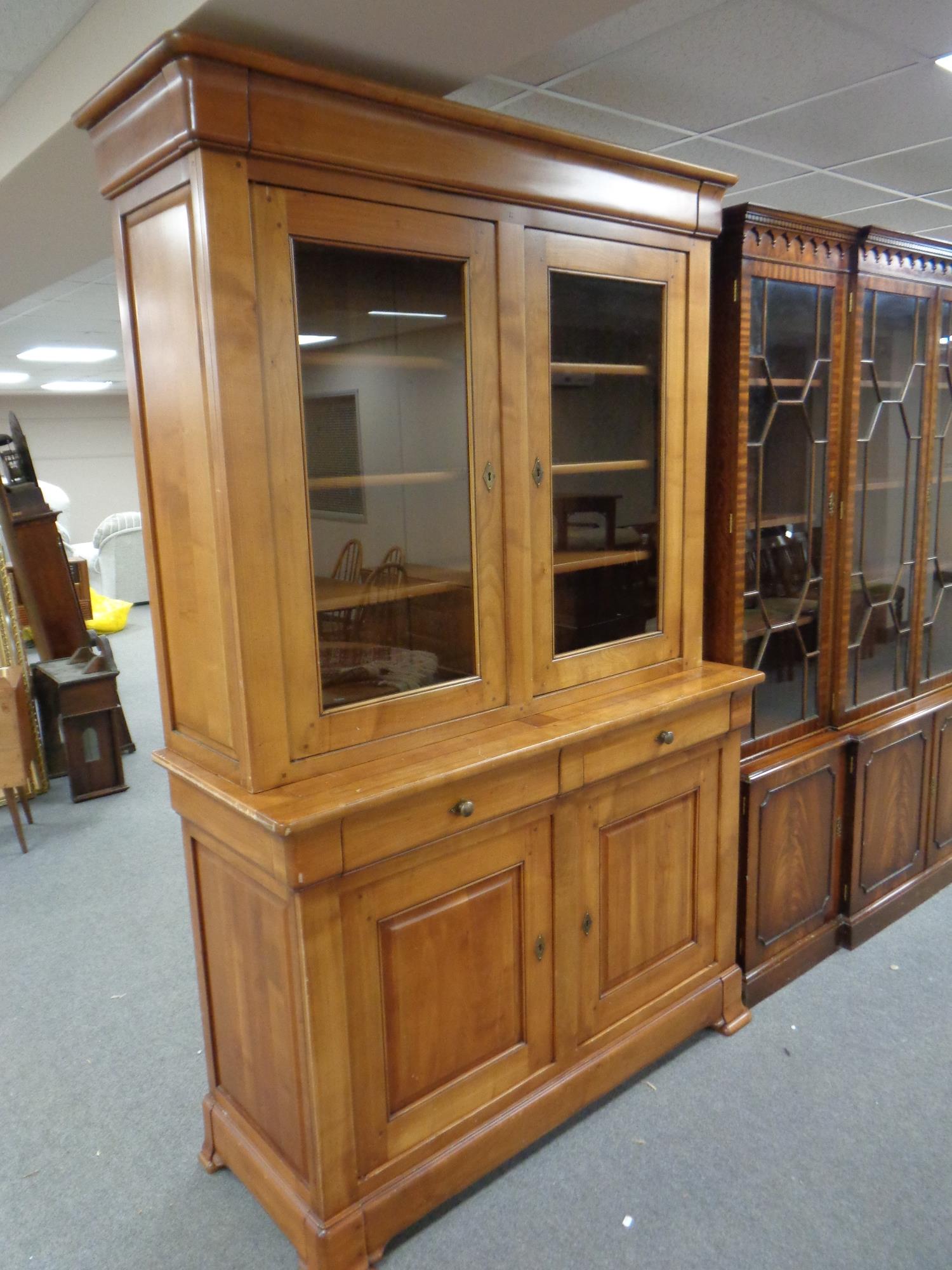 A Boissigny pine double door bookcase fitted cupboards and drawers beneath