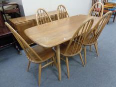 An Ercol solid elm and beech dining table together with a set of six matching high back chairs