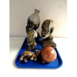A tray containing three carved polished stone tribal busts together with two further animal figures,