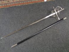 A reproduction sword in scabbard together with a pair of framed monochrome aviation prints