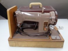 A cased 20th century Singer electric sewing machine