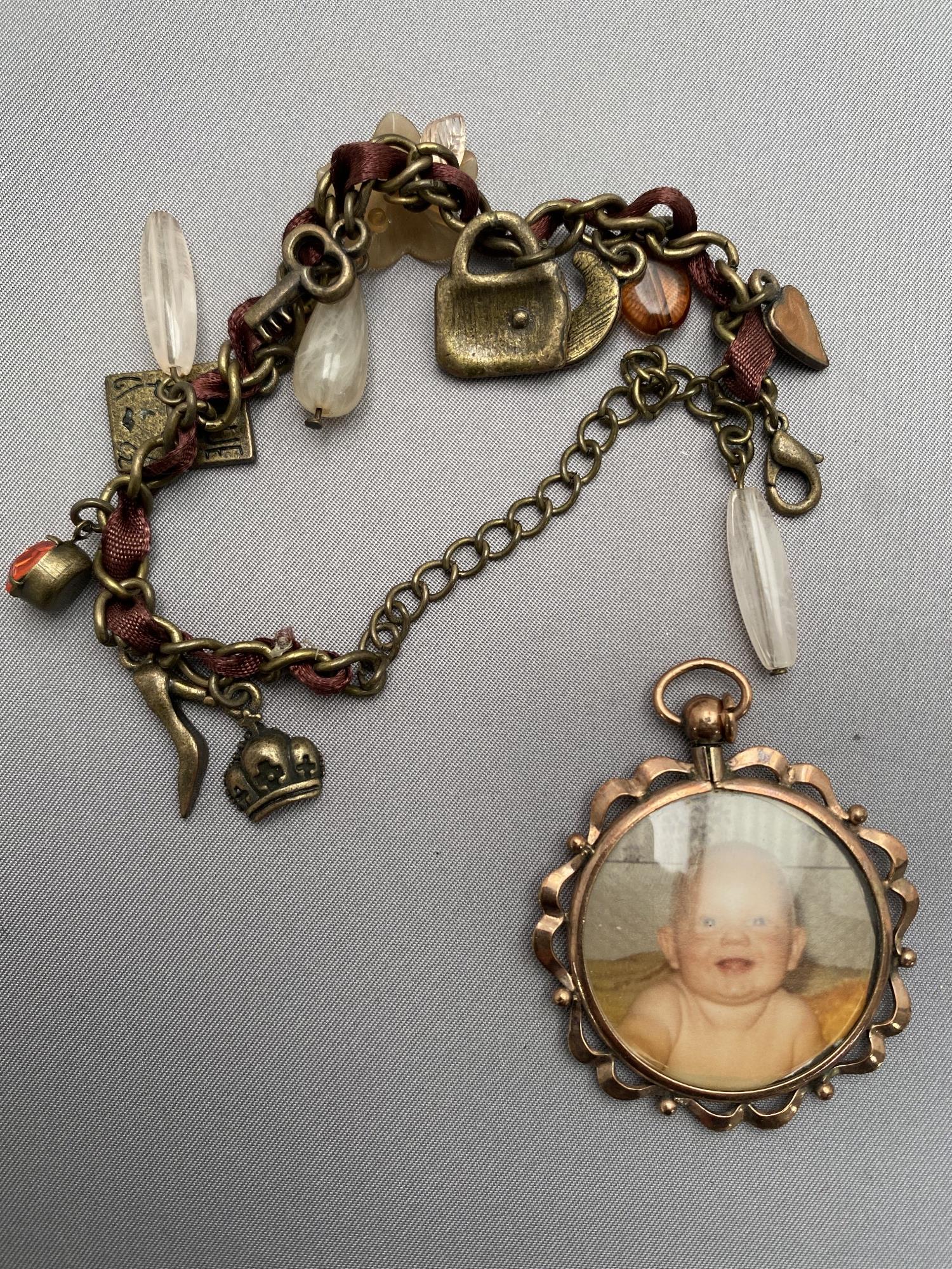 A costume charm bracelet together with a vintage pendant frame