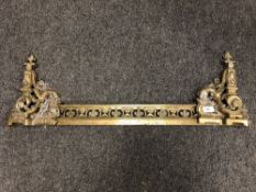 An ornate brass fire fender