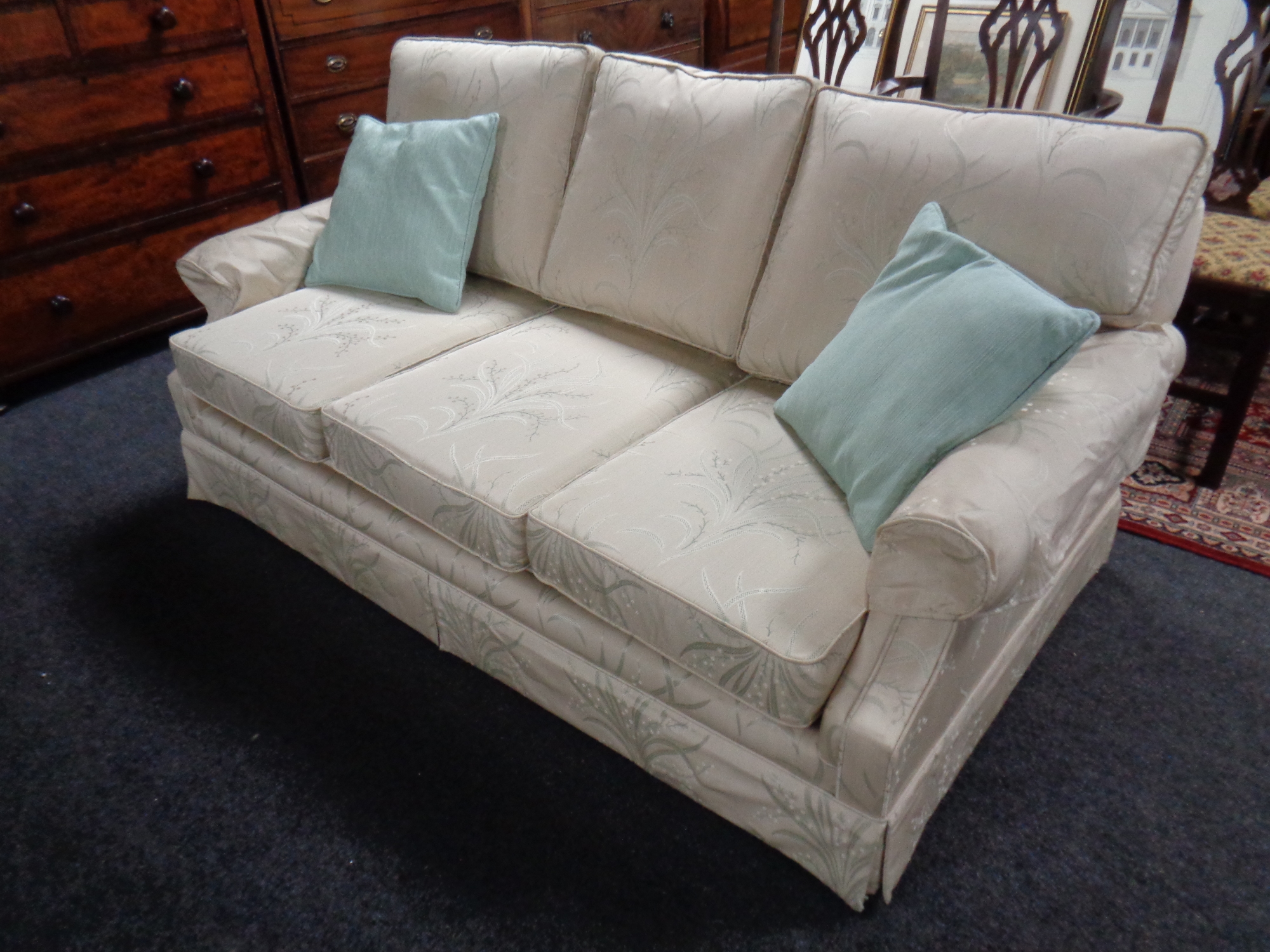 A three seater bed settee upholstered in a cream floral fabric