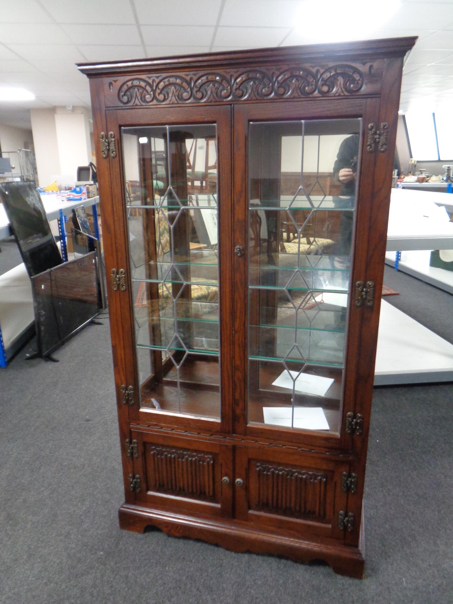 A carved Old Charm double door leaded glass display cabinet fitted cupboards beneath