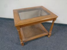An American style glass topped coffee table with bergere under shelf