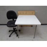 A contemporary swivel office chair together with two folding tables,
