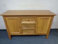 A contemporary oak sideboard fitted cupboards and drawers beneath,