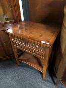 A reproduction yew wood side table fitted three drawers