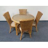 A circular bamboo and wicker glass topped conservatory table together with four chairs