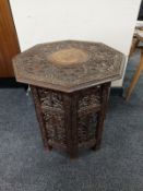 An eastern carved octagonal folding occasional table