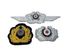 A Group of German Wreath Cap Insignia; to include two white metal examples and a cloth badge.