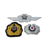 A Group of German Wreath Cap Insignia; to include two white metal examples and a cloth badge.