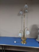 A contemporary brass standard lamp with opaque glass shades,