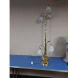 A contemporary brass standard lamp with opaque glass shades,