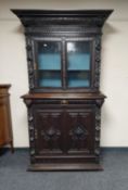 A late Victorian heavily carved stained oak bookcase,