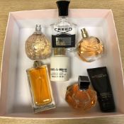 A group of various fragrances including Dolce & Gabbana, Jimmy Choo, Creed,