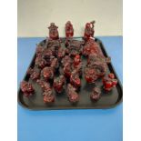A tray containing approximately twenty-seven oriental resin figures of seated buddhas, sages,