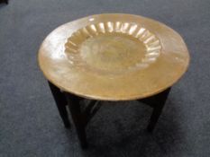 A folding eastern brass topped table