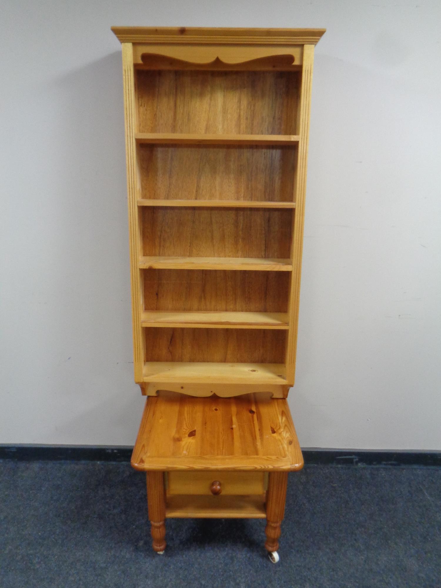 A set of wall mounted pine bookshelves together with a pine lamp table fitted a drawer