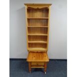 A set of wall mounted pine bookshelves together with a pine lamp table fitted a drawer