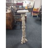 An ornate cast resin jardiniere stand