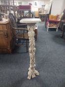 An ornate cast resin jardiniere stand