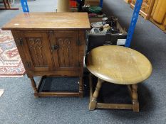 A carved oak double door low cabinet together with a circular oak occasional table
