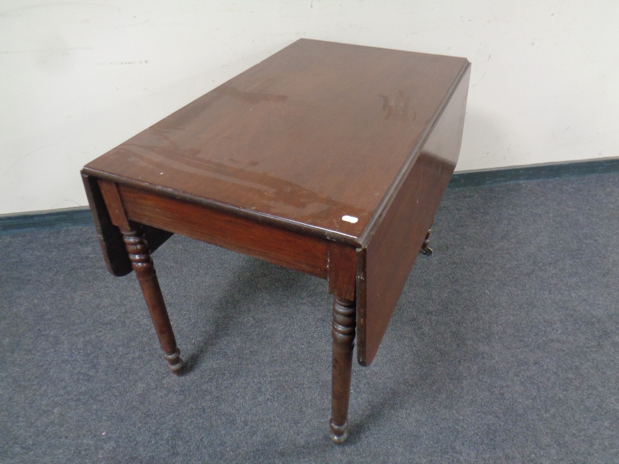 A 19th century mahogany drop leaf table fitted a drawer on casters CONDITION REPORT: