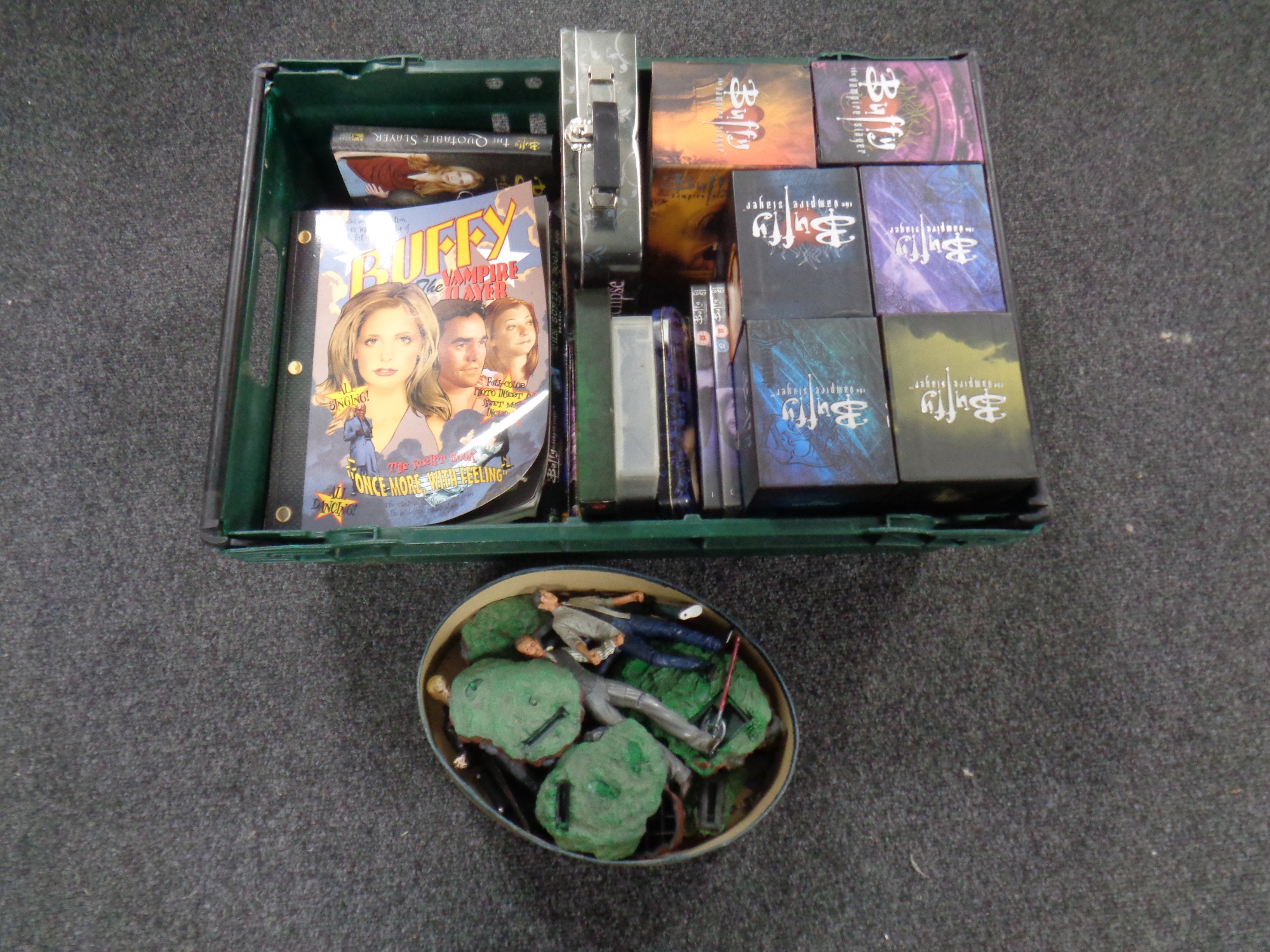 A box containing DVDs and VHS tapes including Buffy script,