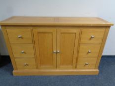 A contemporary oak sideboard fitted cupboards and drawers beneath,