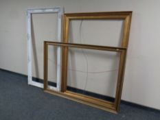 A white painted picture frame together with two gilt examples,