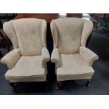 A pair of wingback armchairs in cream upholstery