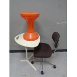 A continental shaped table together with a swivel office chair and a plastic stool