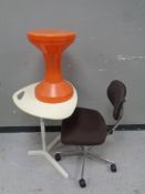 A continental shaped table together with a swivel office chair and a plastic stool