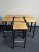 A set of seven plywood topped science lab stools on metal legs