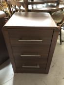 A contemporary wood effect three drawer chest
