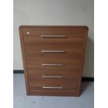 A contemporary wood effect five drawer chest