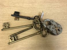 A vintage padlock with key, together with a collection of five further brass and metal keys.