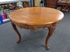 A 19th century carved mahogany circular dining table on cabriole legs,
