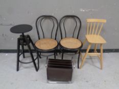 A pair of bergere seated cafe chairs together with two stools and a contemporary magazine rack