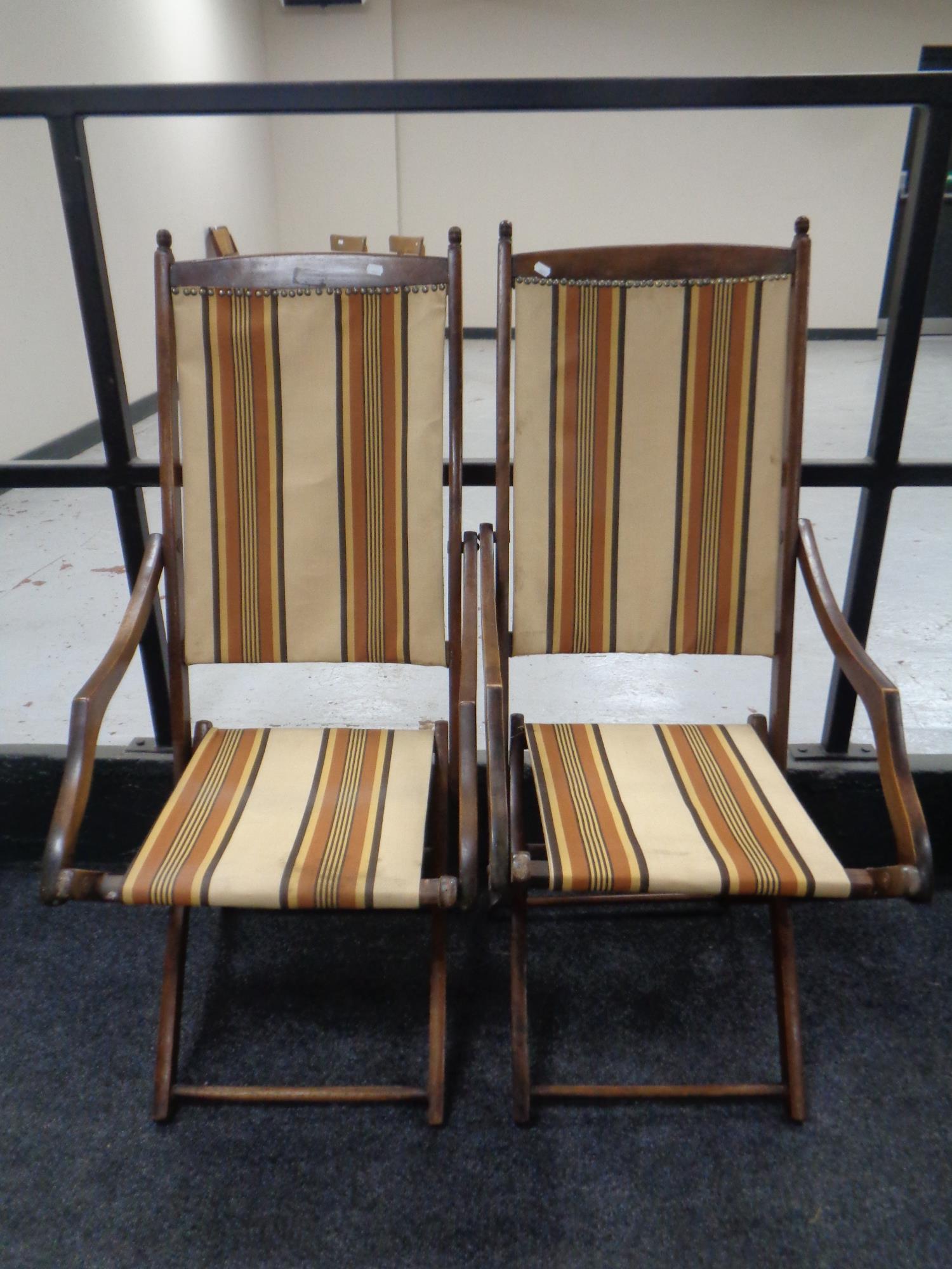 A pair of 20th century beech folding campaign style chairs upholstered in a striped fabric