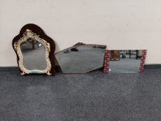 A continental shaped mirror with cherub decoration together with an early 20th century oak bevelled